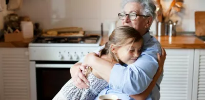 en eldre mann klemmer en jente. Foto