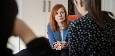 En damen sitter overfor et par. Foto