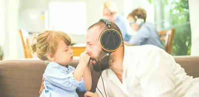 Et barn holder på nesen til en mann. Foto